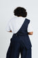 Back view of the Off Cut Denim top showing its asymmetric panel and waist tie